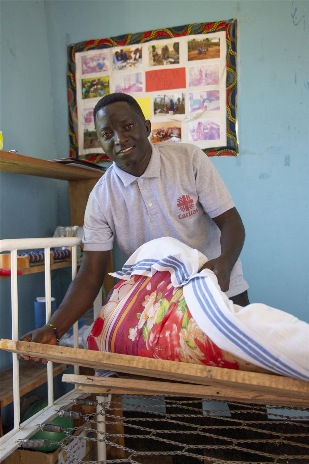 Physiotherapeut aus Rulenge demonstriert die Behandlungsliege, auf der Menschen mit Behindeurng behandelt