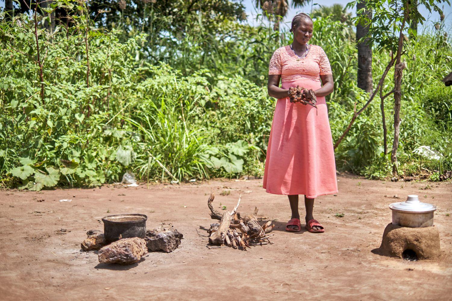 Martha Anywat präsentiert in ihrer Hand die Menge Holz, die sie für den Energiesparofen benötigt.