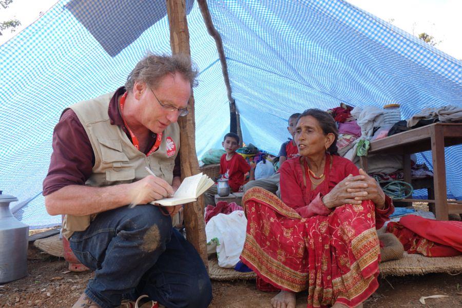 Caritas Mitarbeiter mit einer betroffenen Frau in einem Notzelt