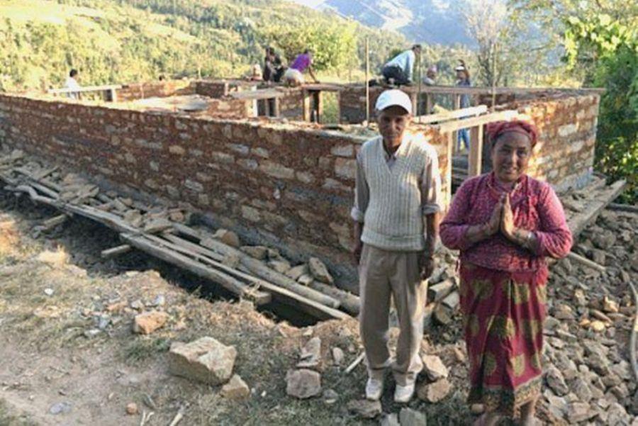 Ein Mann und eine Frau vor einem Rohbau.
