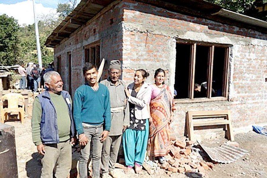 Eine Familie steht vor einem Rohbau.