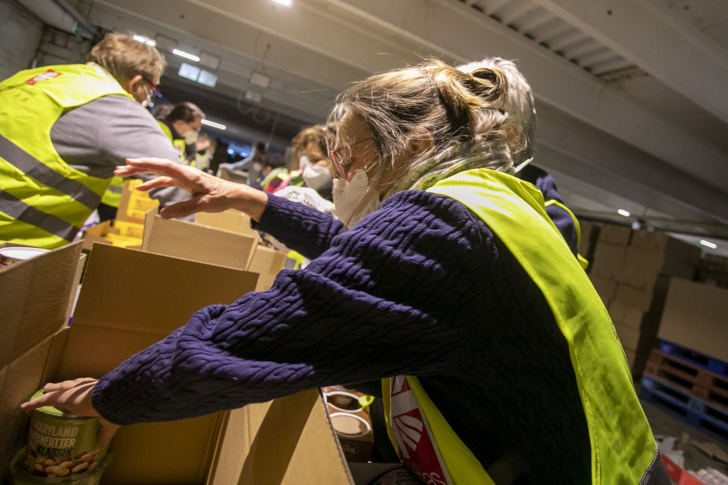 Ehrenamtliche Helfer_innen packen in Münster Caritas-Pakete für die Ukraine.