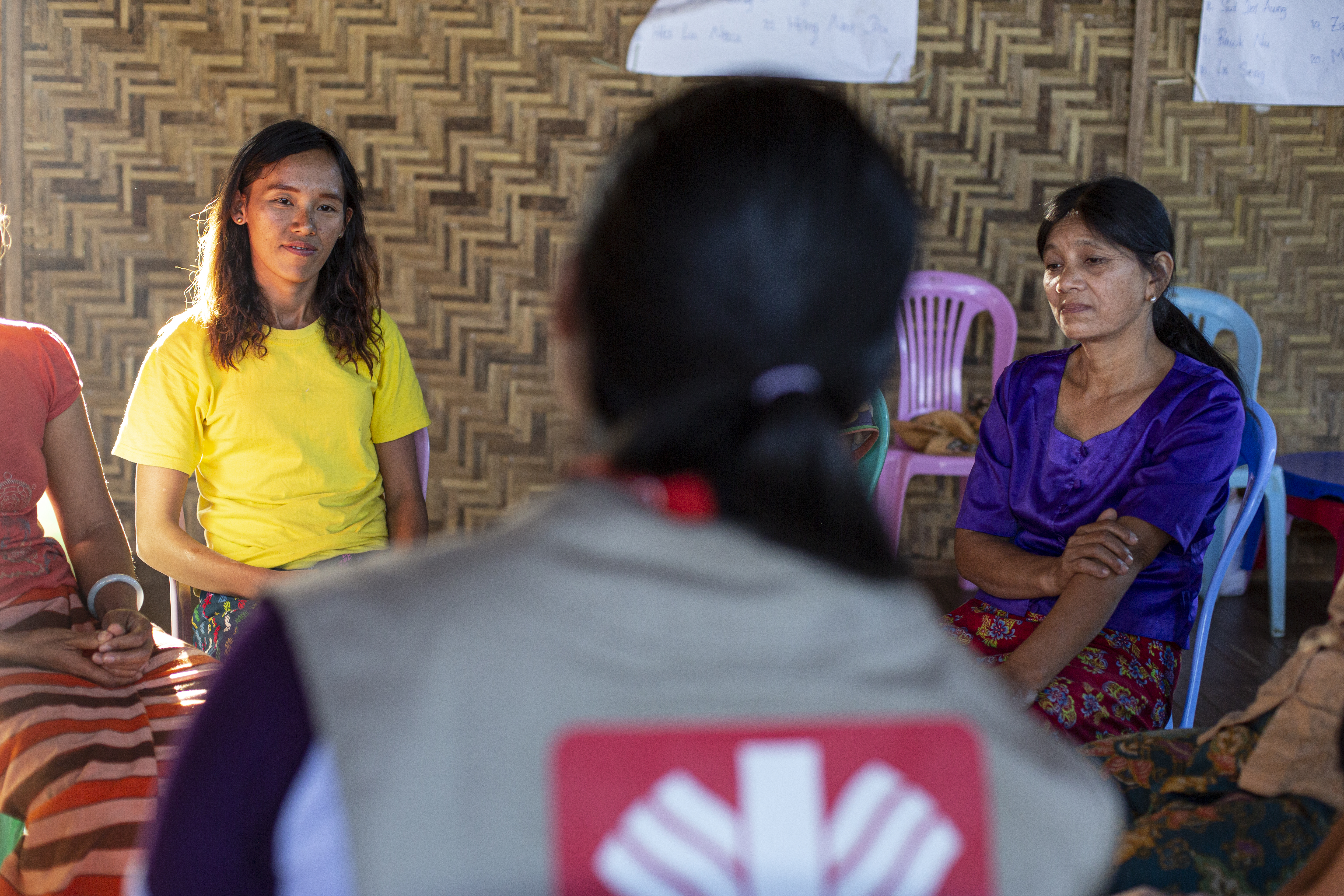Eine Frau von hinten, die mit zwei anderen Frauen spricht.