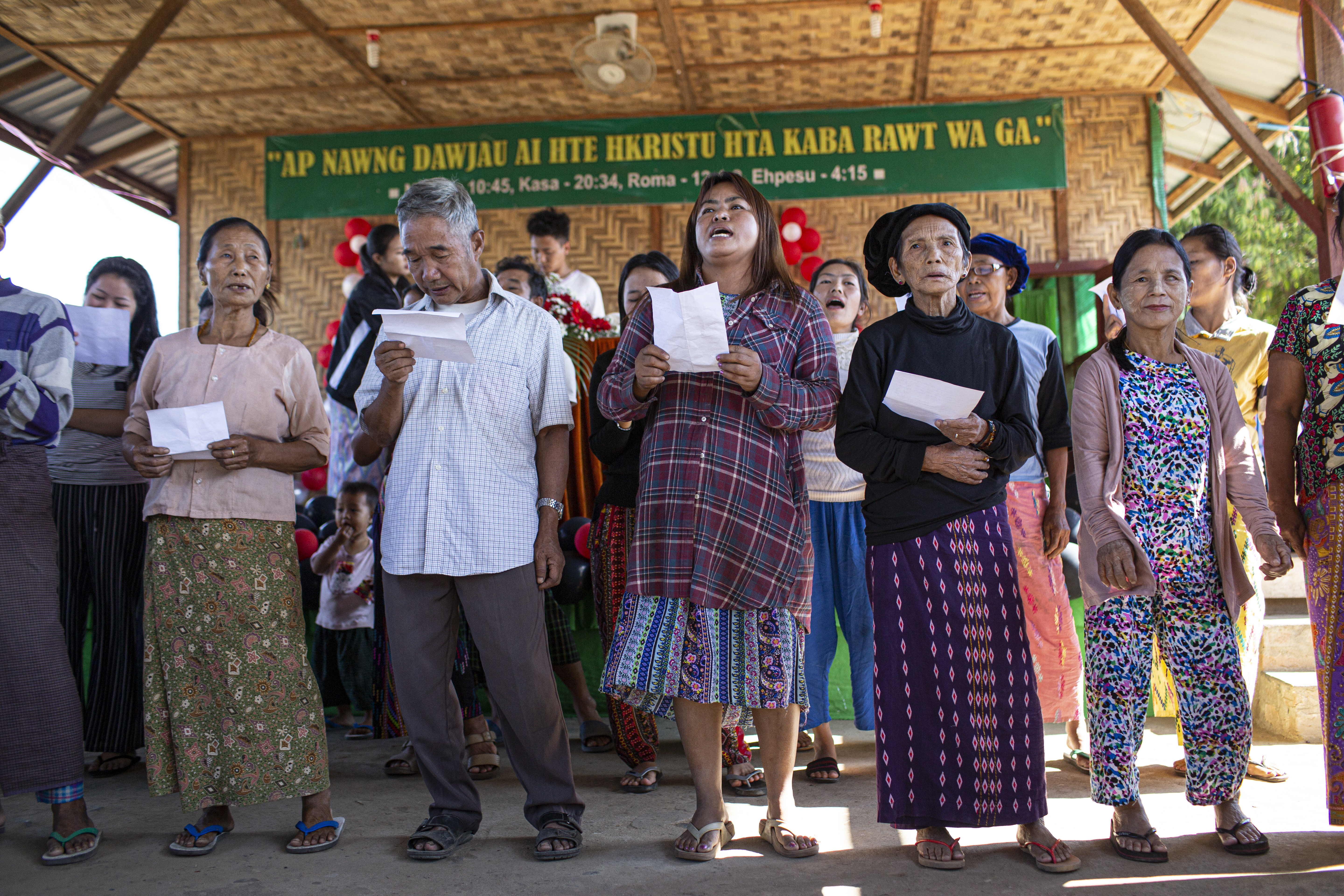 Eine Gruppe Menschen mit weißen Blättern in der Hand und geöffneten Mündern.